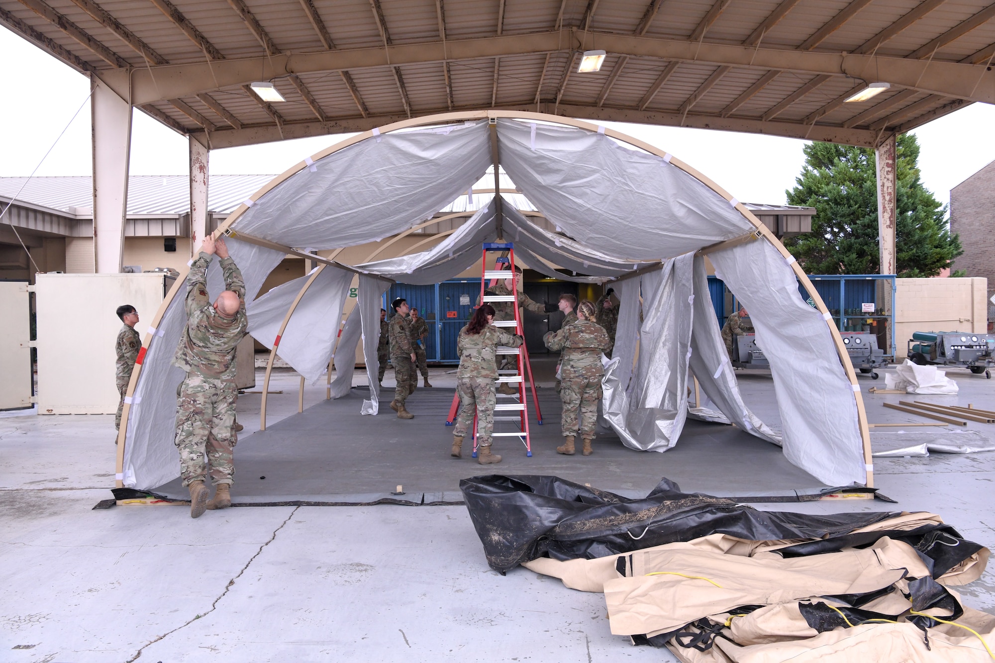 People assemble the frame of a tent.