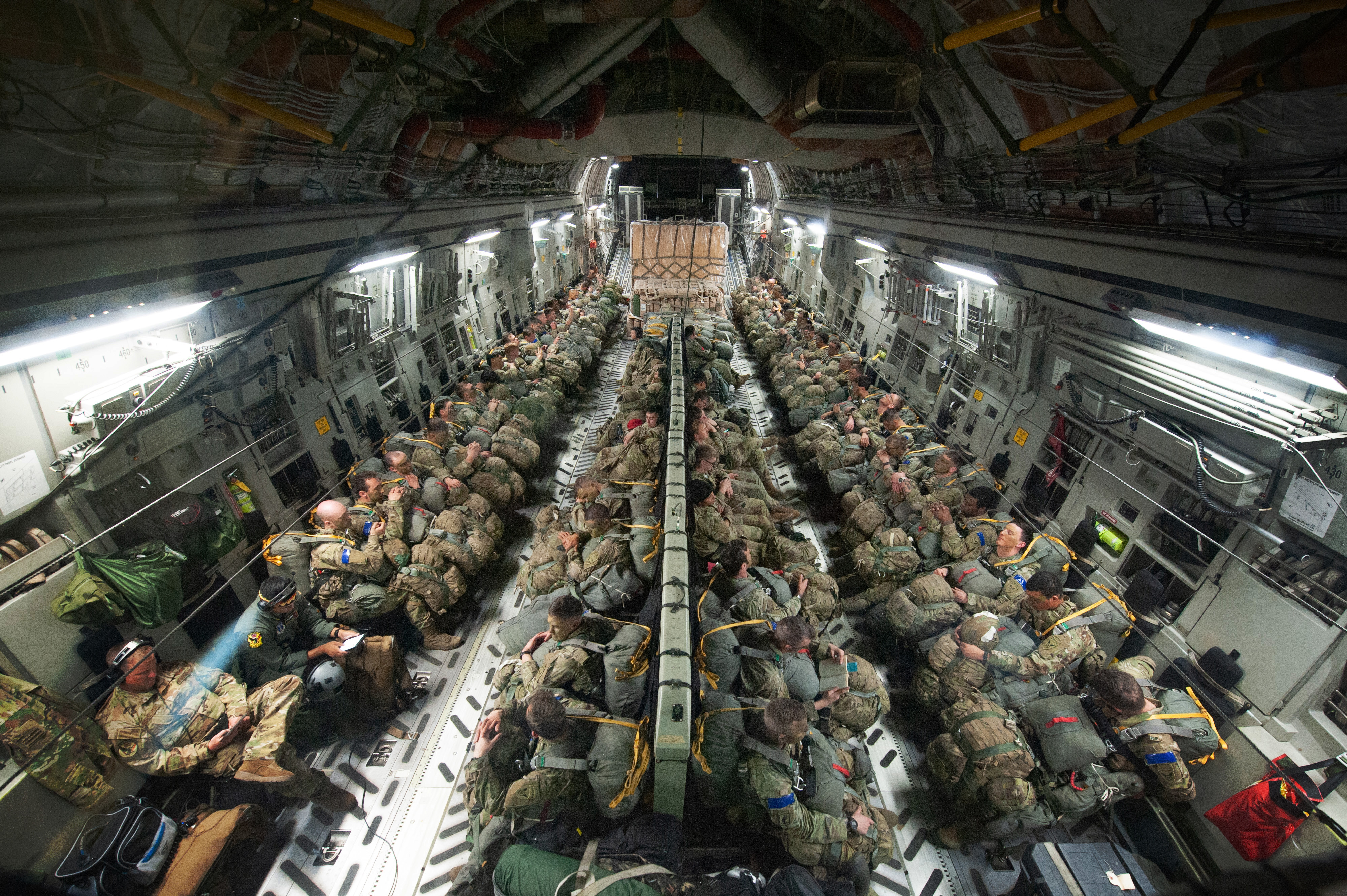 U.S. Army Soldiers seated aboard a U.S. Air Force C-17 Globemaster III assigned to the 204th Airlift Squadron, over the Pacific Ocean prepare for phase one of the Joint Pacific Multinational Readiness Center, Oct. 31, 2023.

JPMRC trains brigade combat teams (BCTs), ultimately enabling brigades and divisions. JPMRC keeps trained, ready forces aggregated and available in-theater for Joint and Combined training. 

(U.S. Air National Guard photo by Airman 1st Class Roann Gatdula)