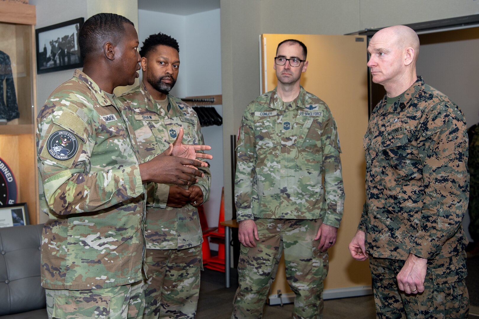 four men in military uniforms stand in a row