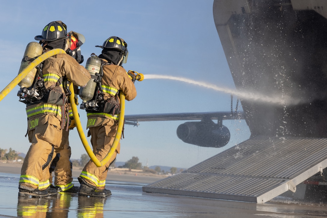 U.S. Marines with Aircraft Rescue and Fire Fighting, Headquarters and Headquarters Squadron, Marine Corps Air Station Yuma, Arizona, extinguishes simulated aircraft fire at the installation, Dec. 15, 2023. ARFF performs routine training that equips Marines with the necessary skills and knowledge to efficiently respond to emergencies.