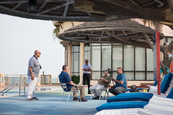 A group of people being interviewed on a patio.