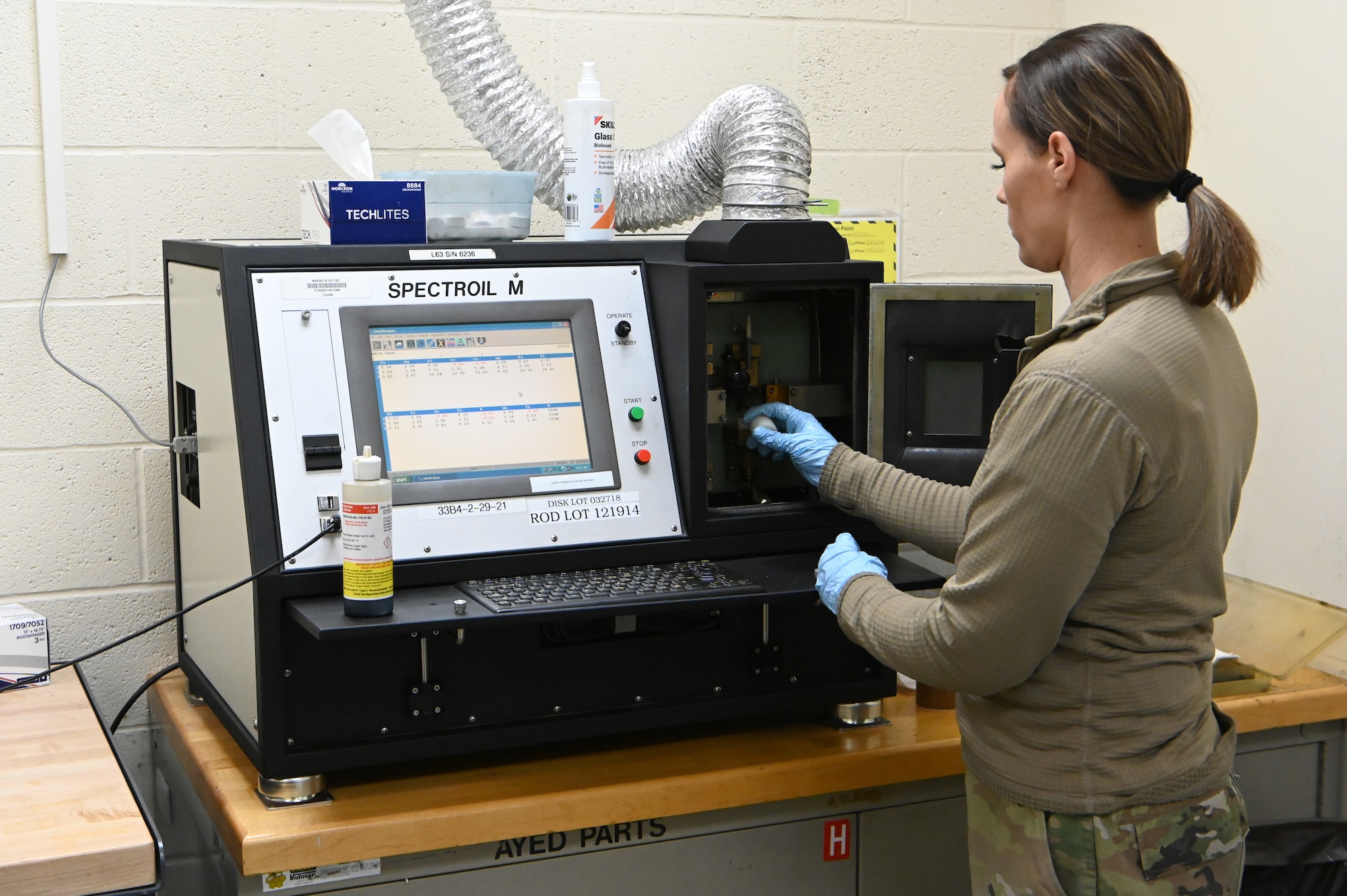 Airmen 1st Class Kellie Marshall places an oil sample into the tester.