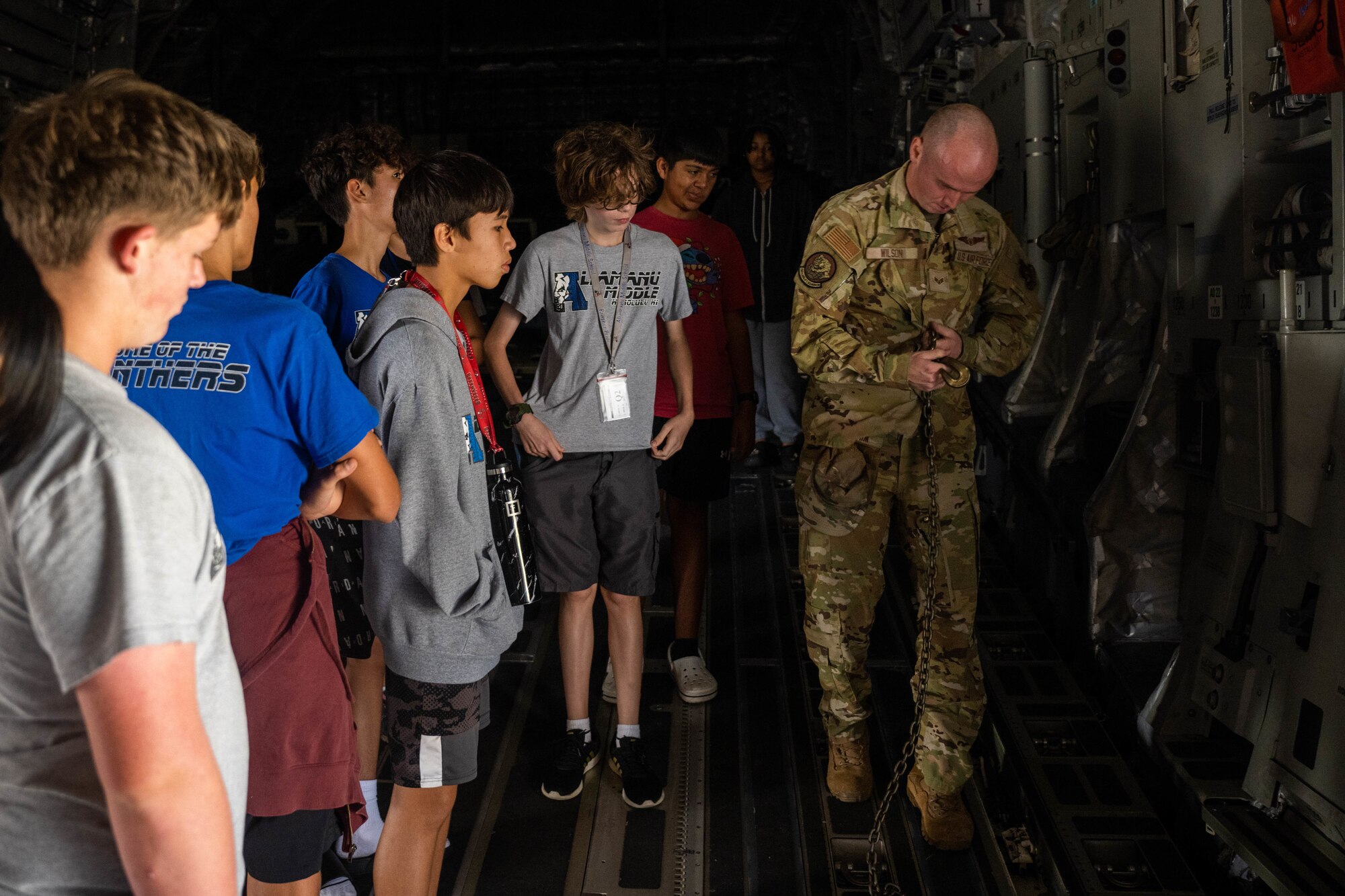 Airmen and students walk in an aircraft.