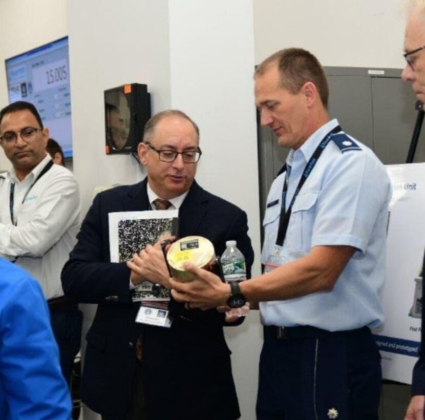 Two men look at PNT technology device (courtesy photo).