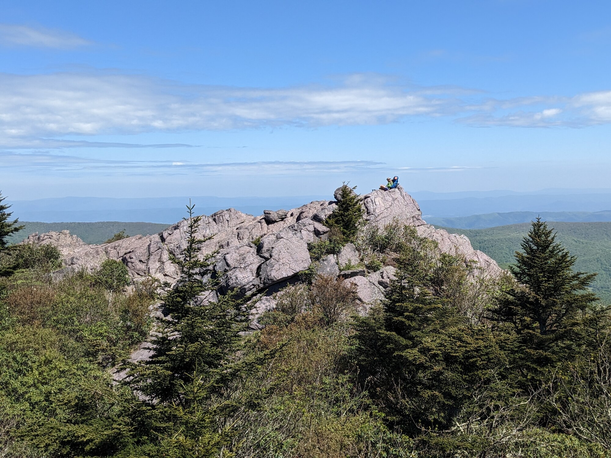 An Airman sits on a boulder overlooking a mountain range