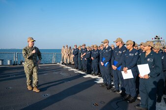 Vice Adm. Brad Cooper presents Sailors aboard USS Carney (DDG 64) with combat medals in Bahrain.