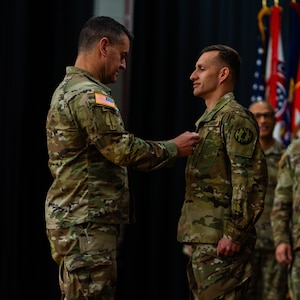 Sergeant Major of the Army in uniform promotes male Soldier