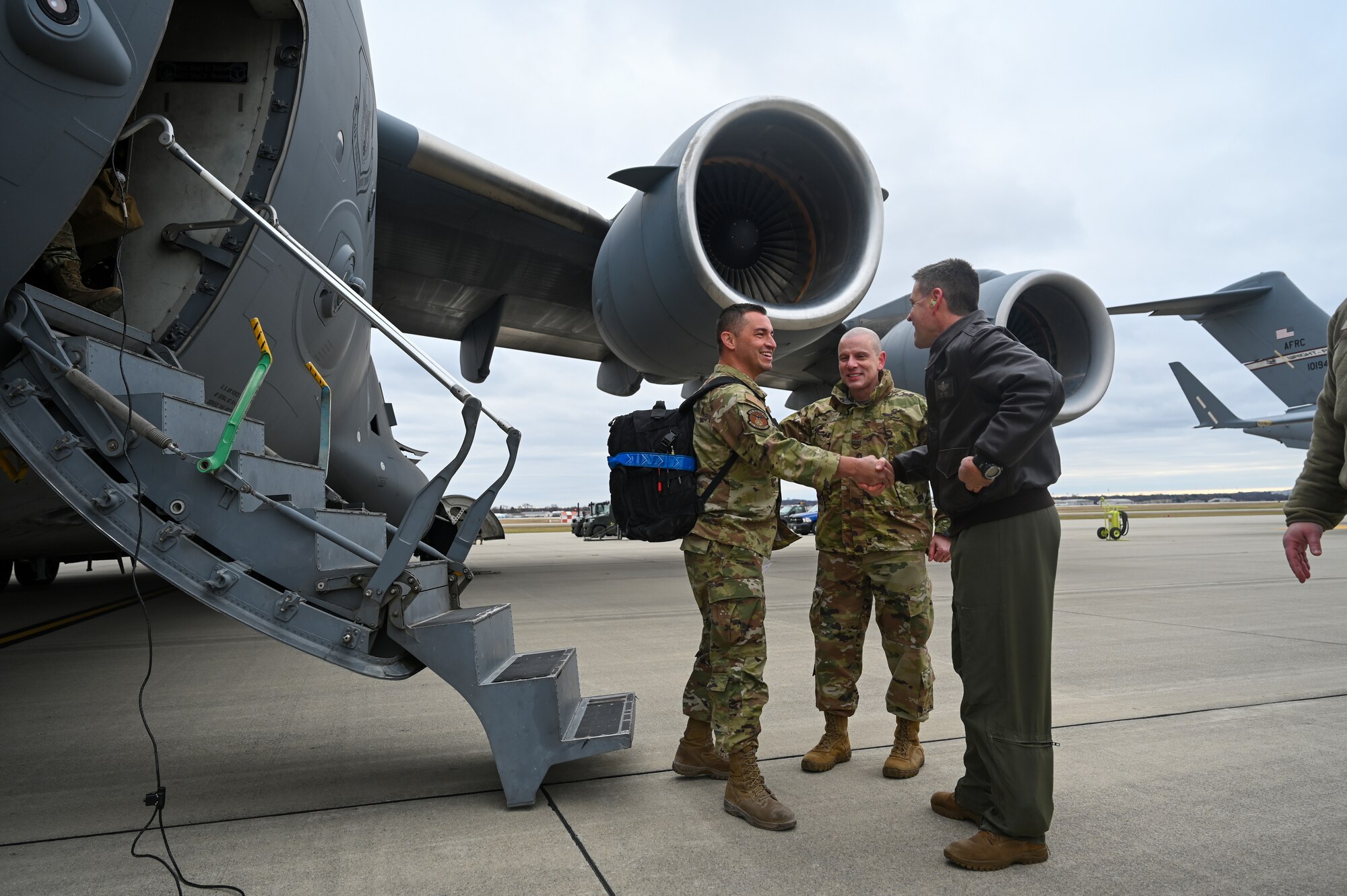 U.S. Air Force Col. Michael T. Baker, right, 445th Operations Group commander, and Col. Matthew T. Muha, 445th Airlift Wing deputy commander, welcome home a 445th AW Reserve Citizen Airman at Wright-Patterson Air Force Base, Ohio, Jan. 4, 2024. The Airman, along with other 445th AW members, returned from a two-month deployment where they transported cargo, personnel and humanitarian aid to various locations. (U.S. Air Force photo by Master Sgt. Patrick O’Reilly)