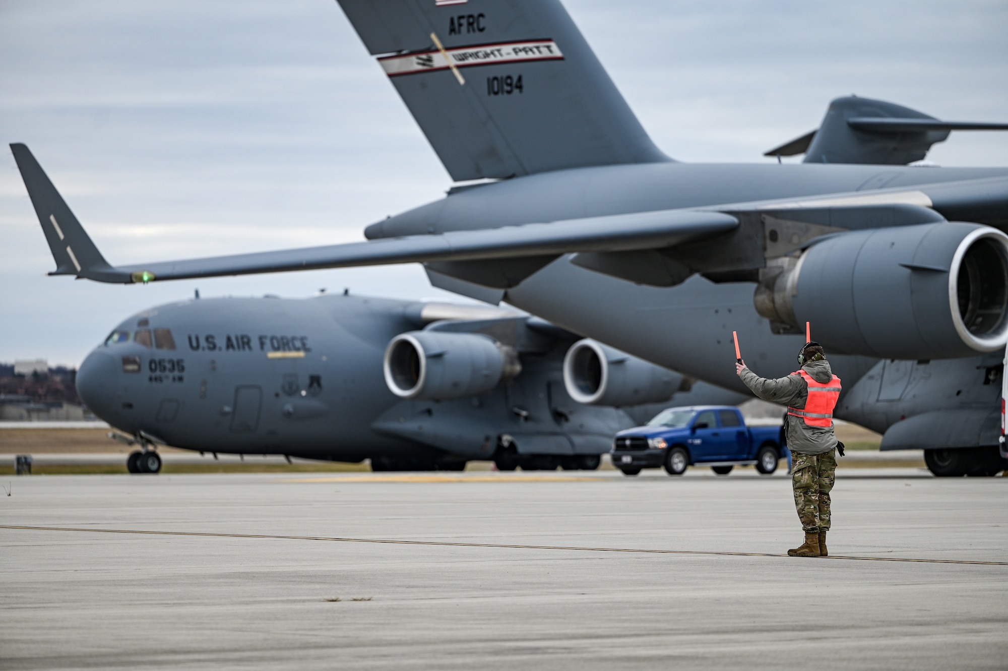 A 445th Airlift Wing Reserve Citizen Airman marshals a wing C-17 Globemaster III aircraft at Wright-Patterson Air Force Base, Ohio, Jan. 4, 2024. The aircraft, crew and passengers returned from a two-month deployment where they transported cargo, personnel and humanitarian aid to various locations. (U.S. Air Force photo by Master Sgt. Patrick O’Reilly)