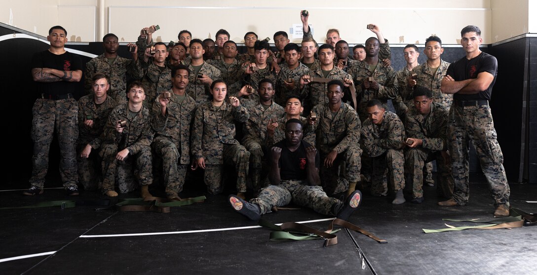 U.S. Marines with III Marine Expeditionary Force and Marine Corps Installations pacific, pose for a group photo after receiving their new Marine Corps Martial Arts Instructor Belts on Camp Hansen, Okinawa, Japan, Dec. 14, 2023. The MAI course is a three-week course that implements physical training and academic instruction for instructor trainees. The demanding physical intensity prepares trainees to perform Marine Corps Martial Arts Program techniques through the different elements of war. Coursework evaluations ensure that all newly graduated instructors have more than enough knowledge to carefully supervise and instruct Marines who are looking to make MCMAP belt advancements. (U.S. Marine Corps photo by Cpl. Thomas Sheng)
