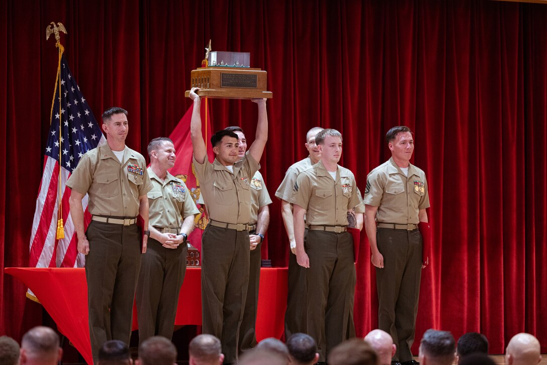 U.S. Marines with the 3d Marine Reconnaissance Battalion, hold up the Rifle Team Trophy during the Marine Corps Marksmanship Competition Far East Awards Ceremony on Camp Hansen, Okinawa, Japan, Dec. 15, 2023. The Rifle Team Trophy is awarded to the highest scoring rifle team at MCMC-Far East. MCMC-Far East is an annual two-week event held to improve Marines’ marksmanship, combat readiness, and weapon proficiency. Marines utilize the first week to learn various techniques and fundamentals from members of the Marine Corps Shooting Team and compete the following week as individuals and teams. (U.S. Marine Corps photo by Cpl. Vincent Pham)