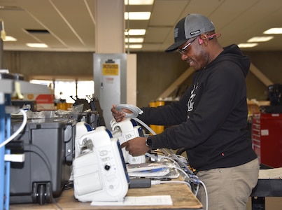 Godwin Gagah, a contract biomedical equipment technician at the U.S. Army Medical Materiel Agency’s Medical Maintenance Operations Division at Hill Air Force Base, Utah, performs maintenance on a patient monitor Nov. 14, 2023. Gagah also has served in the Army National Guard for 13 years. (C.J. Lovelace)