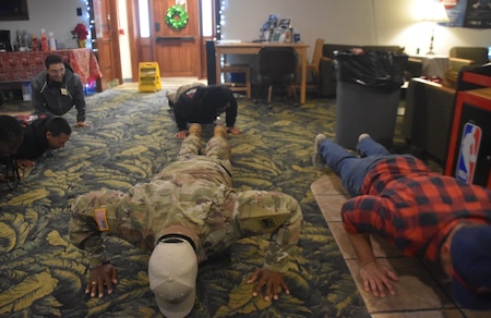 Command Sgt. Maj. Linwood Barrett Jr challenges Soldiers to push ups during Holiday Block Leave at Fort Eisenhower, Ga. These Soldiers opted to stay on post through the holidays and leadership spent many days getting to know them better.