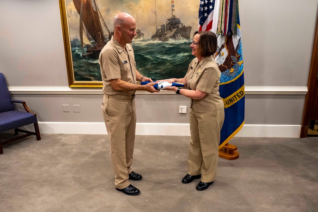 CNO Adm. Lisa Franchetti presents Adm. James Kilby with the Vice Chief of Naval Operations flag during an assumption of office ceremony at the Pentagon.
