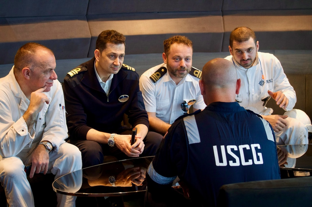 Members of team from U.S. Coast Guard Forces Micronesia/Sector Guam and the U.S. Coast Guard Cruise Ship National Center of Expertise discuss a Certificate of Compliance (COC) exam with officers of the 1,036-foot Maltese-flagged cruise ship MSC Bellissima on its first-ever U.S. port call at the Port of Guam, on Jan. 3, 2024. The U.S. Coast Guard conducts COC exams for new or existing vessels that are embarking passengers from a U.S. port for the first time, carrying U.S. citizens as passengers with initial port calls at U.S. ports, or have undergone significant modifications or alterations, including changes that affect structural fire protection or means of egress, in order to ensure these vessels, meet required safety and regulatory standards. (U.S. Coast Guard photo by Josiah Moss)