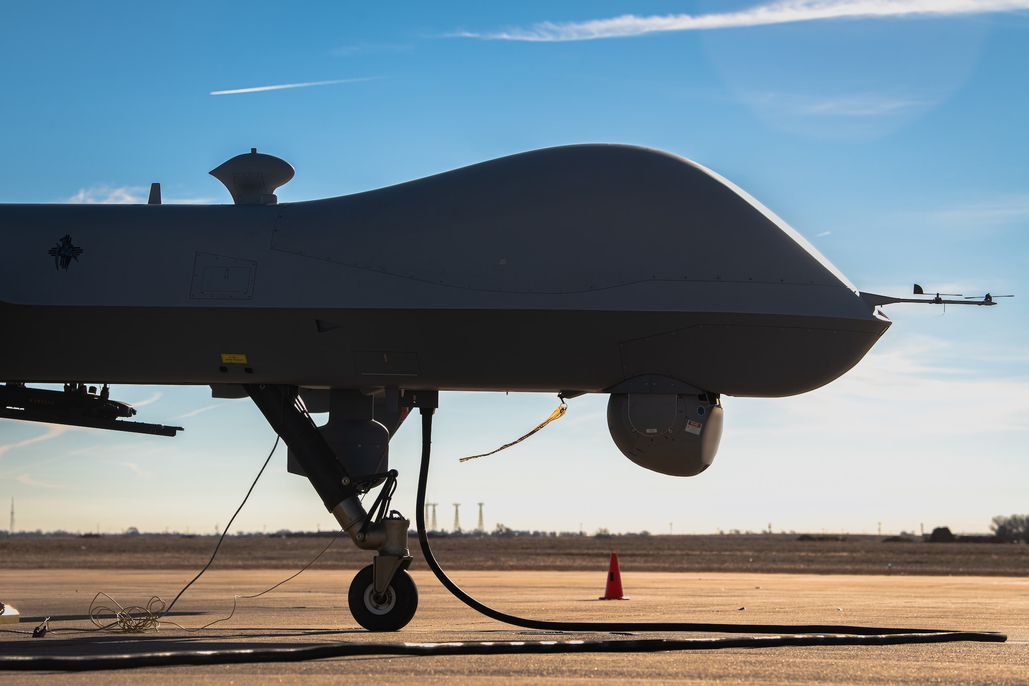 An MQ-9A Reaper remotely piloted aircraft operated by the 3rd Special Operations Squadron undergoes pre-flight checks before an experimental multi-aircraft control flight for the Adaptive Airborne Enterprise (A2E) at Cannon Air Force Base, N.M., Dec. 6, 2023. The flight marked the first attempt to simultaneously operate multiple remote aircraft from a single point of control. (U.S. Air Force photo by Staff Sgt. Vernon R. Walter III) (This photo has been edited for security purposes by blurring out aircraft information)