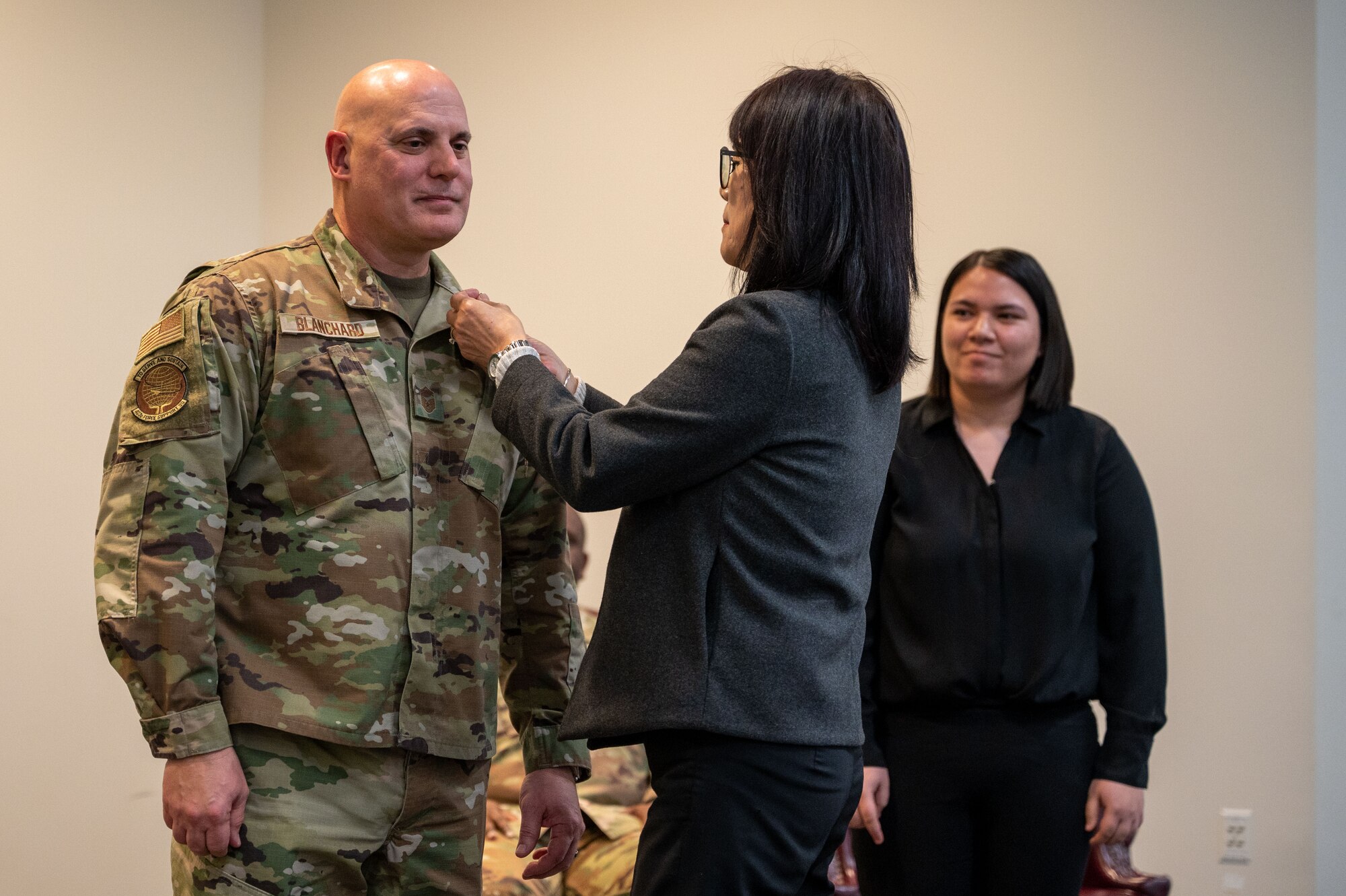 A woman attaches a pin to Blanchard's collar. Their daughter looks on in the background.