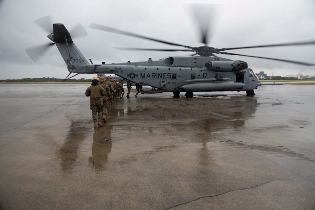 U.S Marines and Sailors with 3rd Marine Logistics Group (MLG), embark on a CH- 53E Super Stallion with Marine Heavy Helicopter Squadron 466, 1st Marine Aircraft Wing, before an air mobility exercise on Marine Corps Air Station Futenma, Okinawa, Japan, Dec. 20, 2023. 3rd Maintenance Battalion, 3rd MLG, executed an air mobility exercise as part of its predeployment training for the 2024 fiscal year campaign season. Air mobility exercises center around familiarization flights that help Marines refine the necessary processes and procedures for the planning and execution of assault support operations. (U.S. Marine Corps photo by Lance Cpl. Aaliyah Hunt)