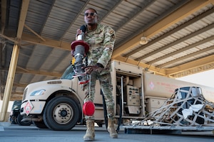 U.S. Air Force Airman 1st Class Kareem Howell, a fuels management specialist, communicates with his dispatch after refueling a C-17 Globemaster III at an undisclosed location in the U.S. Central Command area of responsibility, Dec. 13, 2023. Howell’s passion for aviation paired with the goal of providing a better life for his family inspired him to join the Air Force in 2022. Howell’s journey to the Air Force began in Spanishtown, Jamaica, where he spent most of his childhood and high school years living with his mother and sister until moving to the United States in 2015. (U.S. Air Force photo by Staff Sgt. Lawrence Sena)