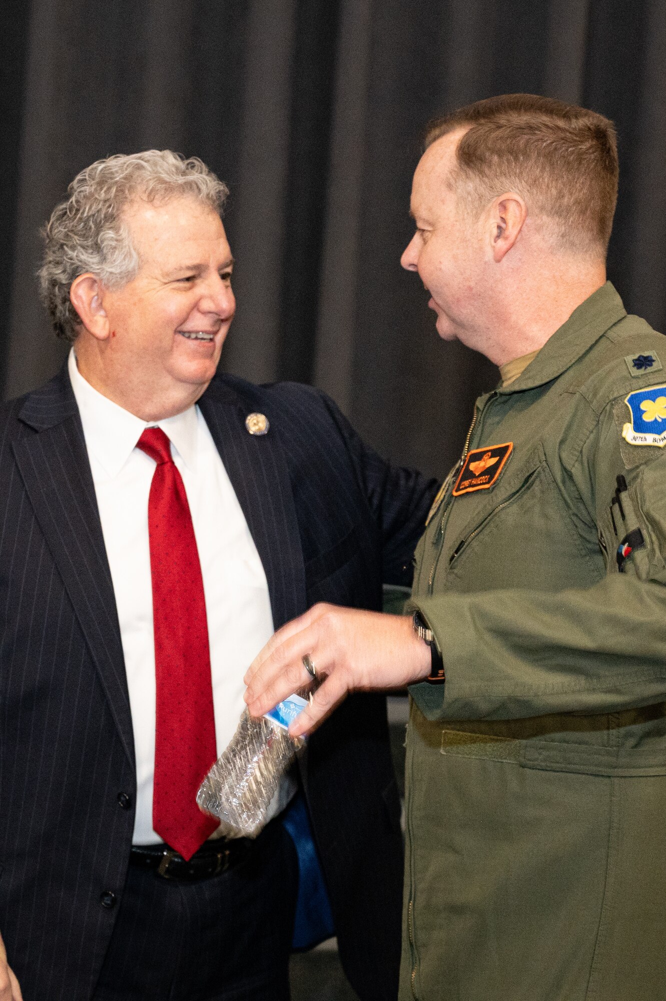 Photo of civilian laughing and talking with Airman