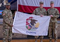 Maj. Gen. Rodney Boyd, Assistant Adjutant General – Army, and Commander of the Illinois Army National Guard, left, and Command Sgt. Maj. Phillip Barber, State Command Sergeant Major, right, present the state of Illinois flag to Capt. Cameron Ward, Commander, 1863rd Finance Management Support Detachment during a mobilization ceremony at the Northwest Armory in Chicago Jan. 5.