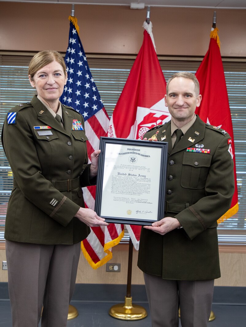 Army officers posing with framed certificate