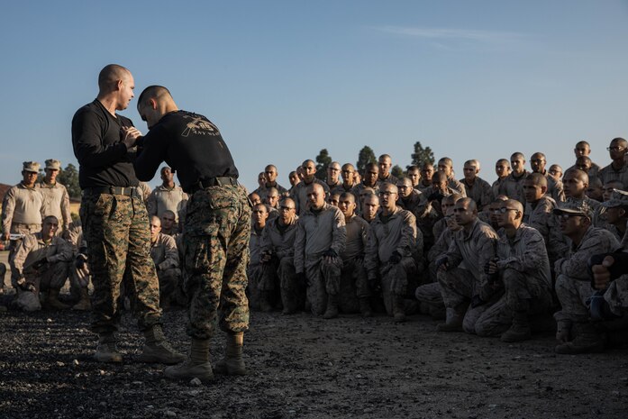 U.S. Marine Corps martial arts instructors Staff Sgt. Jeremy Hill, left, and Staff Sgt. Julian Arroyo, with support battalion, demonstrate MCMAP techniques to Echo Company, 2nd Recruit Training Battalion at Marine Corps Recruit Depot San Diego, Dec. 28, 2023. MCMAP aims to strengthen the mental and moral resiliency of recruits and Marines through realistic combative training, warrior ethos studies, and physical hardening. (U.S. Marine Corps photo by Lance Cpl. Sarah M. Grawcock)