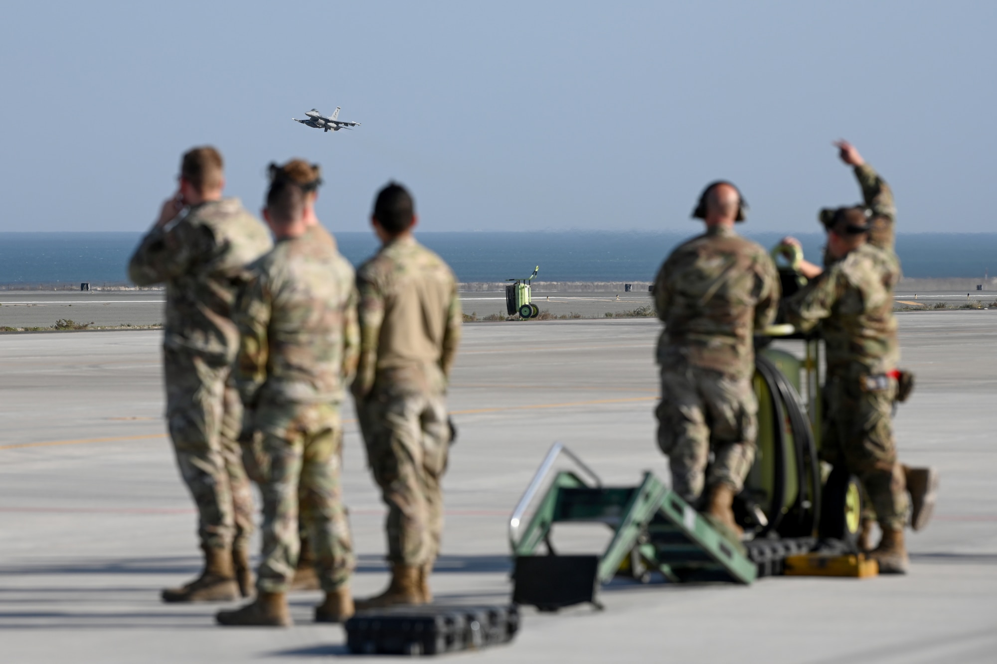 Airmen watch as a U.S. Air Force F-16 Fighting Falcon takes off during Exercise Ballast Cannon 24.3.