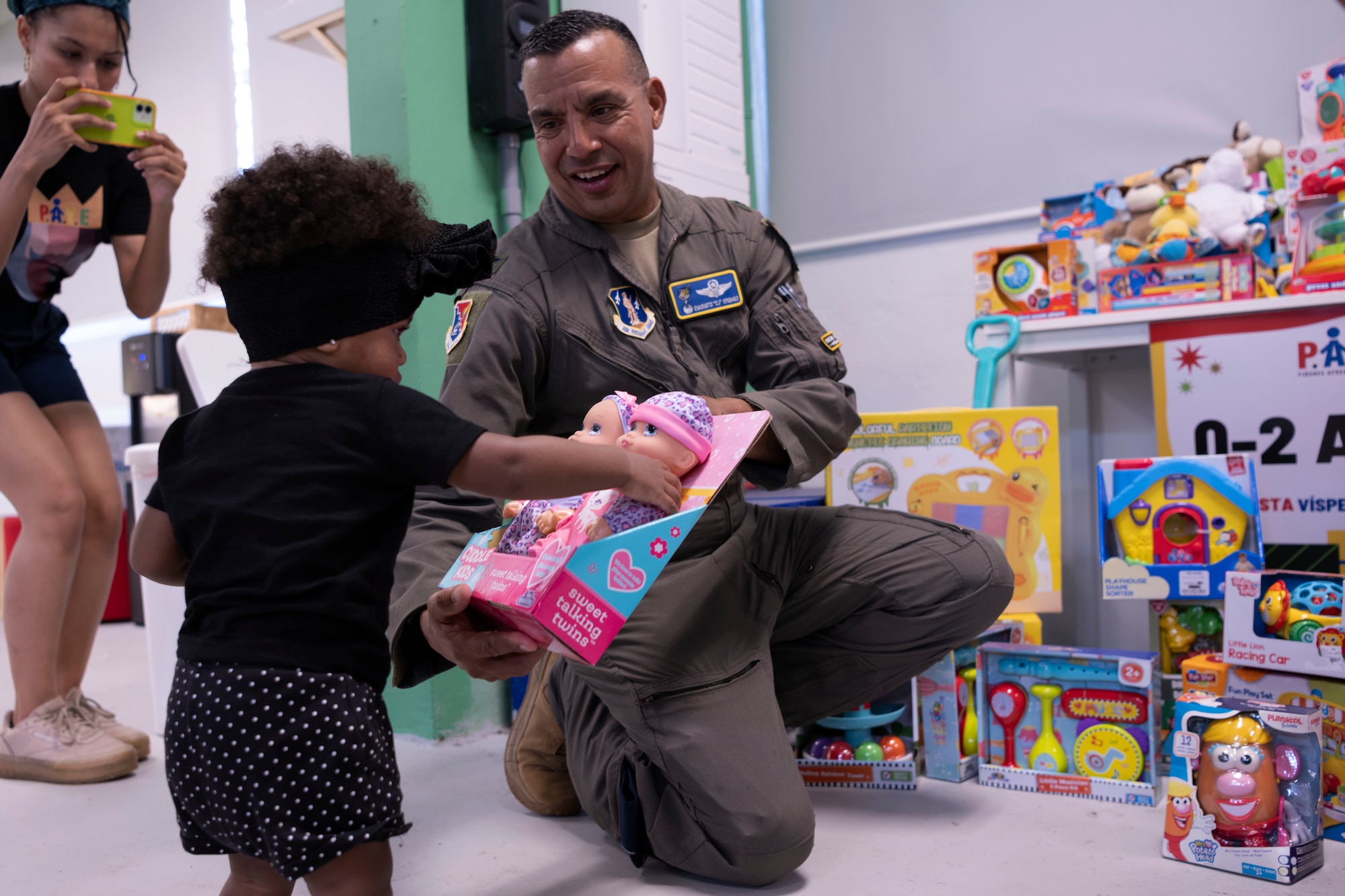 U.S. Air Force Col. Evaristo Orengo III., the 156th Wing commander, Puerto Rico Air National Guard, delivers a gift  to a child during a Three Kings eve event at Loiza, Puerto Rico, Jan. 5, 2024. For 48 consecutive years, the PRANG has honored a Puerto Rican tradition, Three Kings Day, by impacting the Piñones community through a yearly event where the 156th Wing Chiefs Council and U.S. Airmen partnered with local non-profit organizations to impact hundreds of children with ages ranging from newborn to 12-years-old, during the eve of Three Kings Day.(U.S. Air National Guard photo by Airman 1st Class Sharymel Montalvo Velez)