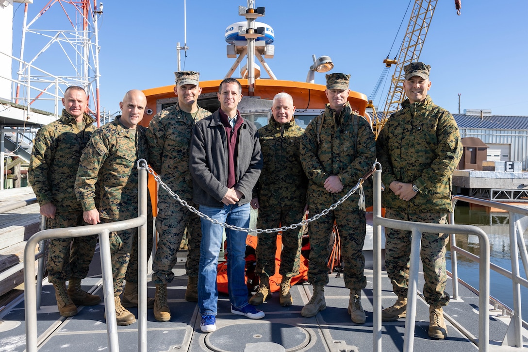 U.S. Marine Corps Col. Brendan Burks, the commanding officer of Marine Corps Air Station Cherry Point, far left, and leaders of the Marine Corps’ development and capabilities stand for a photo on a ferry at MCAS Cherry Point’s outlying range, Bombing Target 11, North Carolina, Dec. 15, 2023. The visitors assessed BT-11 to understand its capabilities to assist designing and developing a modernized Marine Corps to campaign in evolving threat environments. (U.S. Marine Corps photo by Lance Cpl. Lauralle Walker)