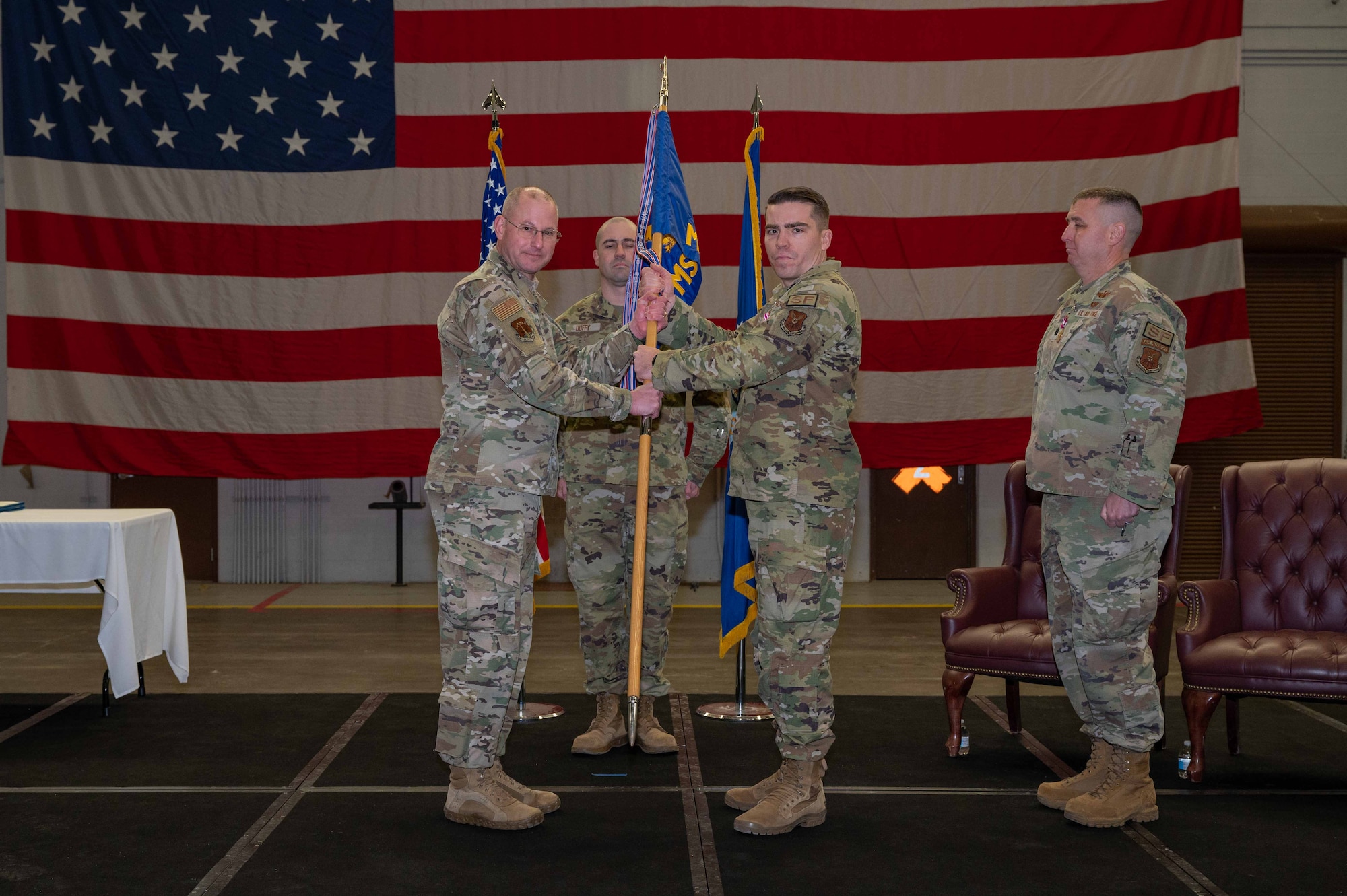 Col. Justin Secrest passes the guidon to Maj. Robert Hudspeth.