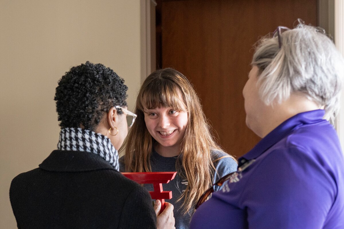 A director and manager congratulate and present an award to a child care provider