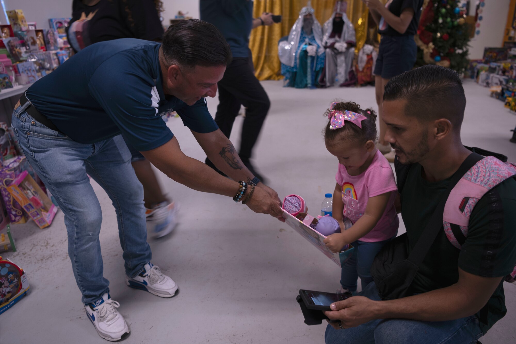 U.S. Air Force Chief Master Sgt. Chief Master Sgt. Neil Larregui, the state command chief, Puerto Rico Air National Guard, delivers a gift to a child during a Three Kings eve event at Loiza, Puerto Rico, Jan. 5, 2024. For 48 consecutive years, the PRANG has honored a Puerto Rican tradition, Three Kings Day, by impacting the Piñones community through a yearly event where the 156th Wing Chiefs Council and U.S. Airmen partnered with local non-profit organizations to impact hundreds of children with ages ranging from newborn to 12-years-old, during the eve of Three Kings Day. (U.S. Air National Guard photo by Airman 1st Class Sharymel Montalvo Velez)