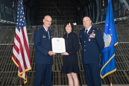 Col. William Gutermuth, 433rd Airlift Wing commander, presents the Certificate of Appreciation to Kelly Miller