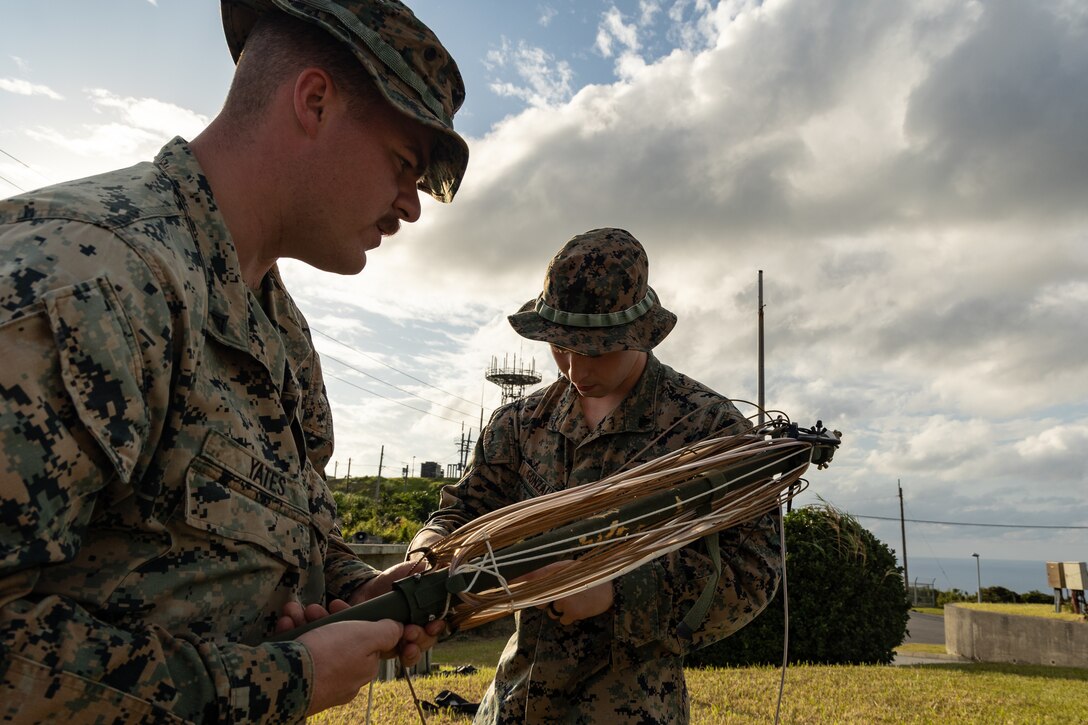 U.S. Marine Corps Lance Cpl. Michael Yates, left, and Cpl. Robert Gonzalez, right, both radio operators, both with 7th Communication battalion, III Marine Expeditionary Force Information Group, set up an antenna during the field training exercise portion of Resolute Dragon 23 at Kumejima, Okinawa, Japan, Oct. 23, 2023. RD 23 is an annual bilateral exercise in Japan that strengthens the command, control, and multi-domain maneuver capabilities of Marines in III MEF and allied Japan Self-Defense Force personnel. Yates is a native of Owls Head, Maine and Gonzalez is a native of Star, Idaho. (U.S. Marine Corps photo by Cpl. William N. Wallace)