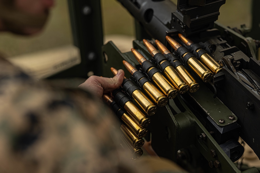 U.S. Marine Corps Cpl. Zachary Posey, left a heavy equipment mechanic with 3rd Maintenance Battalion, 3rd Marine Logistics Group, reloads a M2 Browning .50 Caliber machine gun at Camp Hansen, Okinawa, Japan, Dec. 22, 2023. The reason for the training was to increase their lethality, survivability, and capability when it comes to employing the M2 .50 Caliber machine gun in a mounted platform. (U.S. Marine Corps photo by Lance Cpl. Weston Brown)