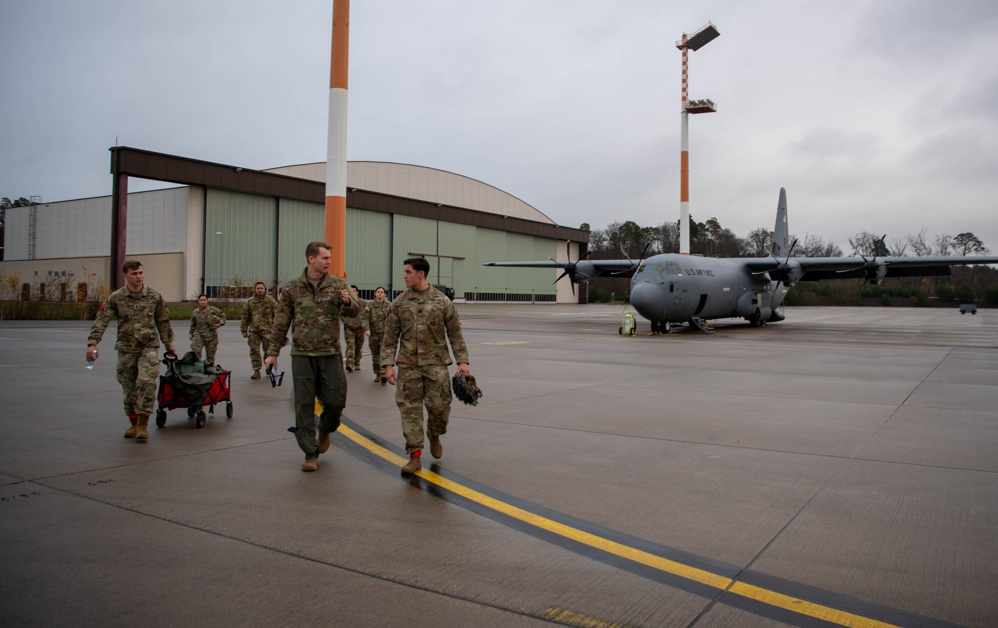 Members from the U.S. Air Force and Army walk on the flightline in preparation for a local flight out of Ramstein Air Base, Germany, Dec. 15, 2023.