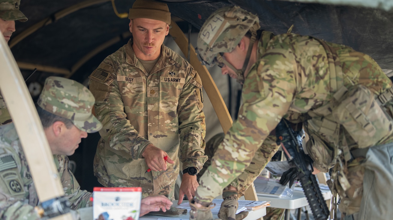 U.S. Army Maj. Colin Begy (left), assigned to the 30th Medical Brigade, 21st Theater Sustainment Command, assists in grading Sgt. Caleb Norman (right), a medic assigned to the 1-4 Infantry Regiment, during the day-time land navigation as Norman competes to earn his Expert Field Medical Badge (E3B) on November 6, 2023, at Grafenwohr South Land Navigation Course, Germany. Day and nighttime land navigation is the second step in competing for these badges. Testing takes one week, and pass rates are usually at or below 20% of the starting number of candidates on their journey to earn their badge.