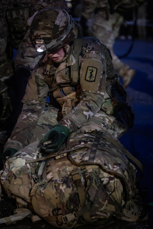U.S. Army Cpt. Caroline Barton, assigned to 30th Medical Brigade, weighs her rucksack during Expert Infantryman Badge (EIB), Expert Soldier Badge (ESB) and Expert Field Medical Badge (EFMB), E3B at Vilseck, Germany Nov. 10, 2023.  E3B is EIB, ESB and EFMB combined and tests candidates' physical and mental abilities while executing critical individual tasks and training, which increases readiness by improving the armed forces' ability to respond more effectively and efficiently.  (U.S. Army Reserve photo by Spc. William Kuang)