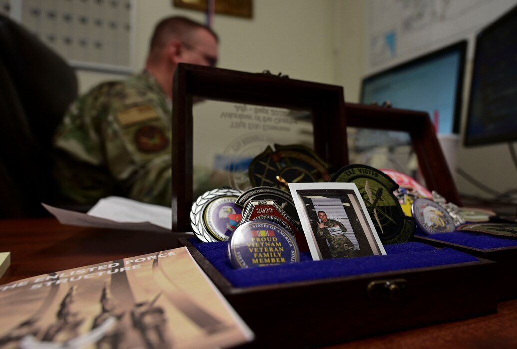 Keepsakes are displayed on the front of U.S. Air Force Master Sgt. Emerson’s desk, Goodfellow Air Force Base, Oct. 5, 2023. Emerson requested to be stationed at Goodfellow to be closer to his family. (U.S. Air Force photo by Airman 1st Class Madison Collier)