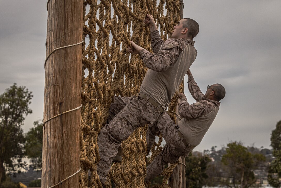 U.S. Marine Corps recruits with India Company, 3rd Recruit Training Battalion, climb over an obstacle during the confidence course at Marine Corps Recruit Depot San Diego, Dec. 18, 2023. The confidence course challenges recruits physically, mentally, and spiritually through obstacles that require confidence in their strength, balance, and determination. (U.S. Marine Corps photo by Lance Cpl. Jacob B. Hutchinson)