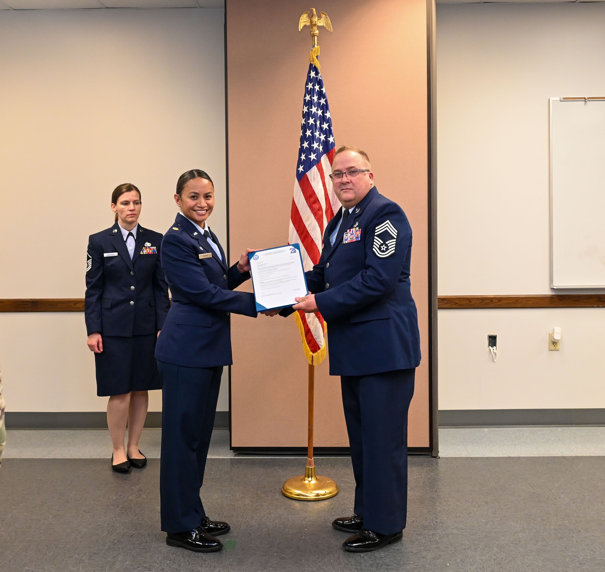 Maj. Valerie A. Mafnas, 74th Aerial Port Squadron commander, presents a certificate of retirement to Chief Master Sgt. Steven Purvis, 74th APS superintendent, during a ceremony at the 74th APS building San Antonio, Texas, Jan. 6, 2024. Purvis began his Air Force career in 1991 as an equipment management clerk with the 351st Supply Squadron at Whiteman AFB, Missouri and retired with more than 30 years of military service. (U.S. Air Force photo by Staff Sgt. Adriana Barrientos)