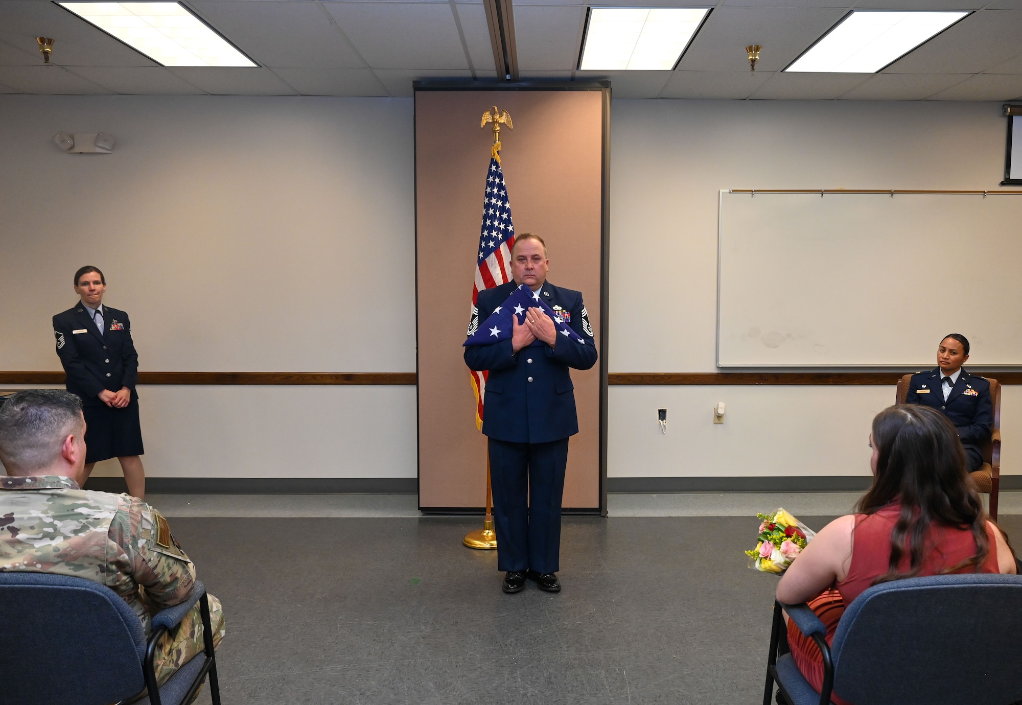 Chief Master Sgt. Steven Purvis, former 74th Aerial Port Squadron superintendent, embraces a folded U.S. flag during his retirement ceremony at the 74th APS building San Antonio, Texas, Jan. 6, 2024. Purvis retired with more than 30 years of military service. (U.S. Air Force photo by Staff Sgt. Adriana Barrientos)