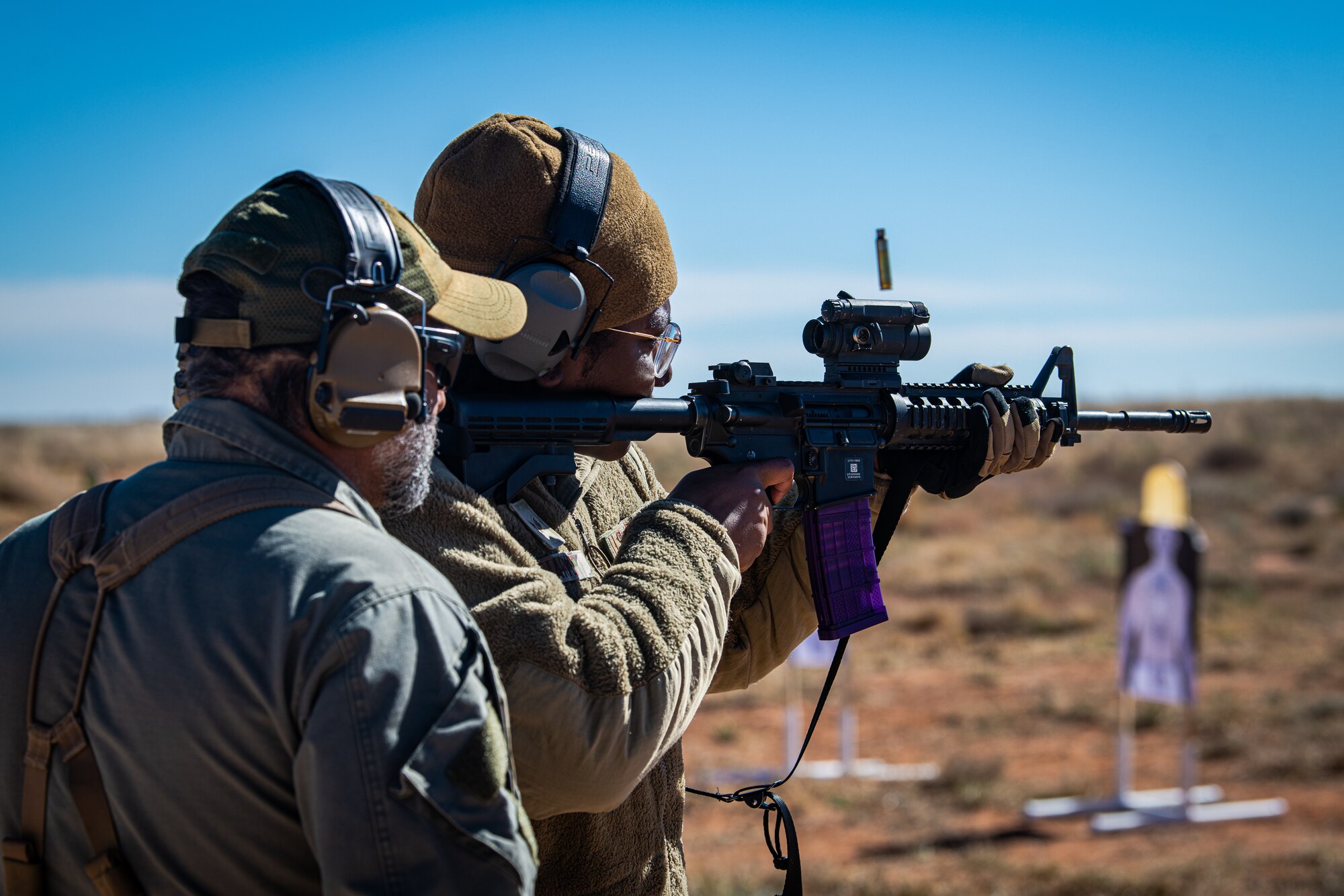 U.S. Air Force Senior Airman Dejanee Harvey, 27th Special Operations Mission Sustainment Team supply journeyman, fires an M4A1 carbine under the guidance of a 371st Special Operations Combat Training Squadron instructor at the Special Operations Task Unit-192 course at Melrose Air Force Range, N.M., Nov. 2, 2023. The course took place over three weeks, instructing participants in a variety of skills aimed at enhancing their field survival capabilities. (U.S. Air Force photo by Staff Sgt. Vernon R. Walter III)