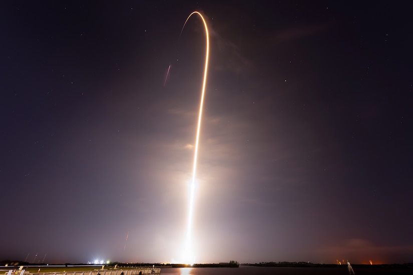 A bright stream of light shoots up into the night sky.