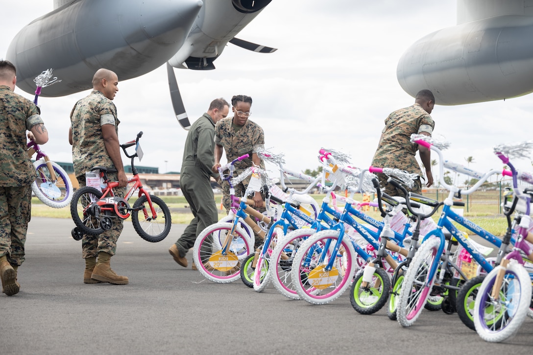 U.S. Marines with Marine Aerial Refueler Transport Squadron (VMGR) 153, Marine Aircraft Group 24, 1st Marine Aircraft Wing and 4th Reconnaissance Battalion pass out toys to children in Maui, Hawaii on Dec. 21, 2023. VMGR-153 supported the Toys for Tots mission by transporting personnel and toys to assist in delivering a message of joy and hope to children throughout the holiday season. (U.S. Marine Corps photo by Lance Cpl. Clayton Baker)