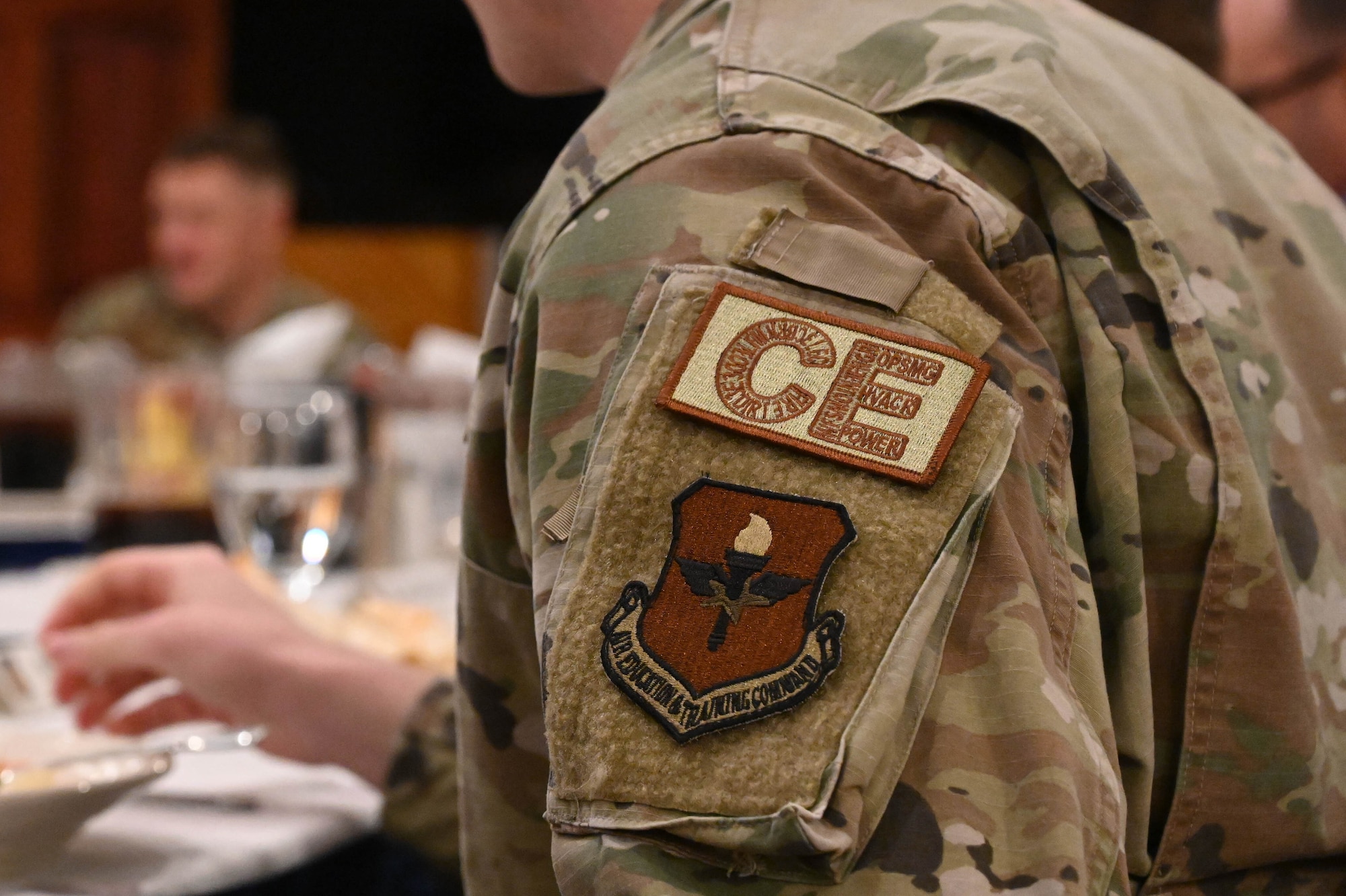 U.S. Air Force Capt. Tyler Stout, 97th Civil Engineer (CE) Squadron chief of operations engineering, wears a CE patch during a luncheon at Altus Air Force Base, Oklahoma, Dec. 12, 2023. The inside lettering of the patch features each career field in CE. (U.S. Air Force photo by Senior Airman Miyah Gray)