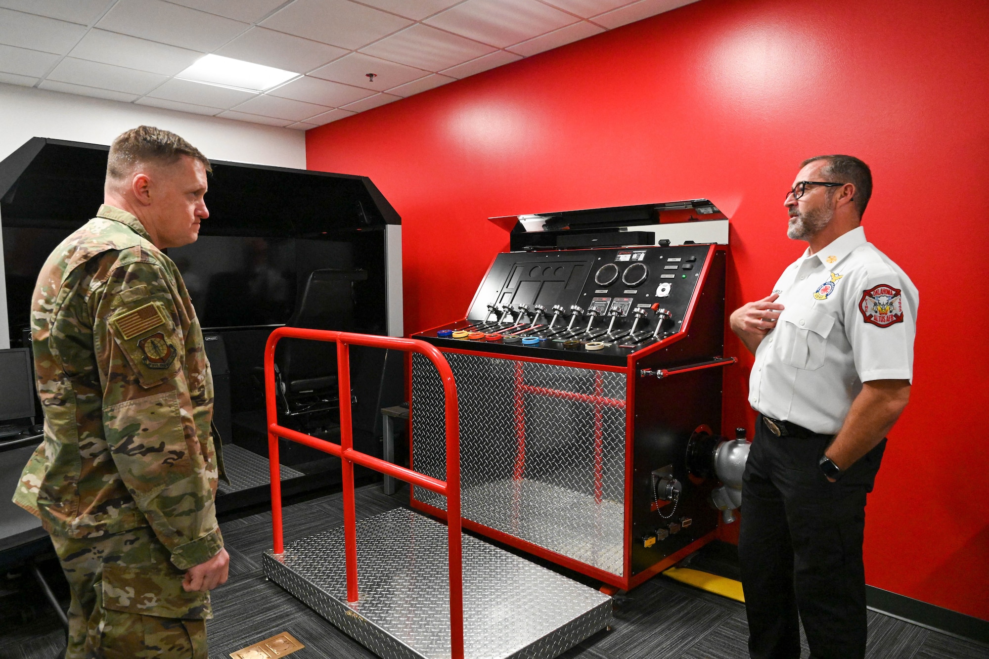 Phillip Fourreaux, 97th Civil Engineer Squadron fire chief, presents firefighter training apparatuses to U.S. Air Force Brig. Gen. William Kale, Air Force Civil Engineer Center commander, during a tour at Altus AIr Force Base, Oklahoma, Dec. 12, 2023. The devices allow for firefighters to train for real-life scenarios without overuse of actual equipment. (U.S. Air Force photo by Senior Airman Miyah Gray)