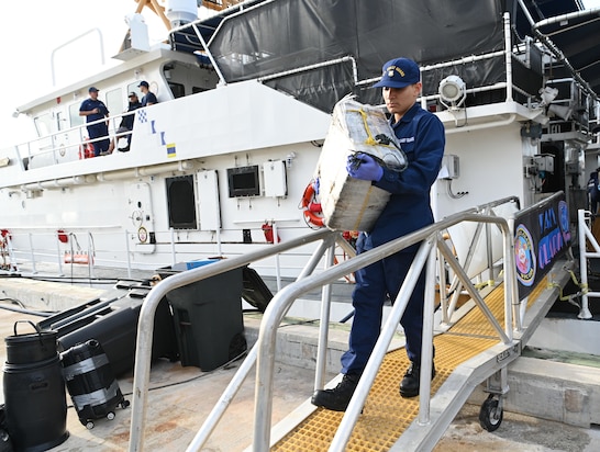A crew member from Coast Guard Cutter Margaret Norvell offloads illicit narcotics at Coast Guard Base Miami, Jan. 9, 2024.