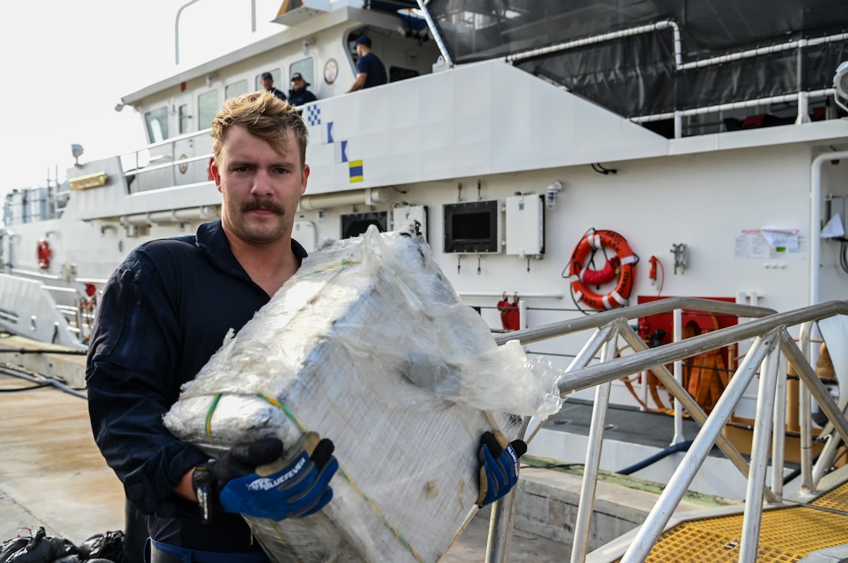 A crew member from Coast Guard Cutter Margaret Norvell offloads illicit narcotics at Coast Guard Base Miami, Jan. 9, 2024.